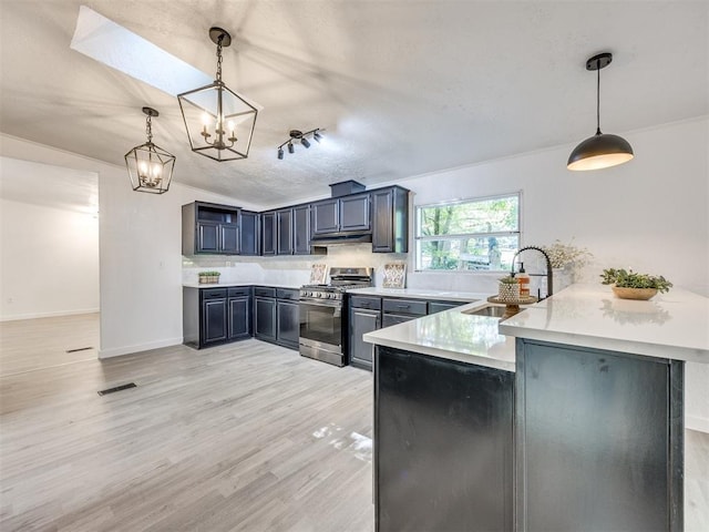 9200 Hollow Rd, Newalla, OK 74857 - kitchen with stainless steel gas range, a peninsula, a chandelier, light wood-type flooring, and pendant lighting