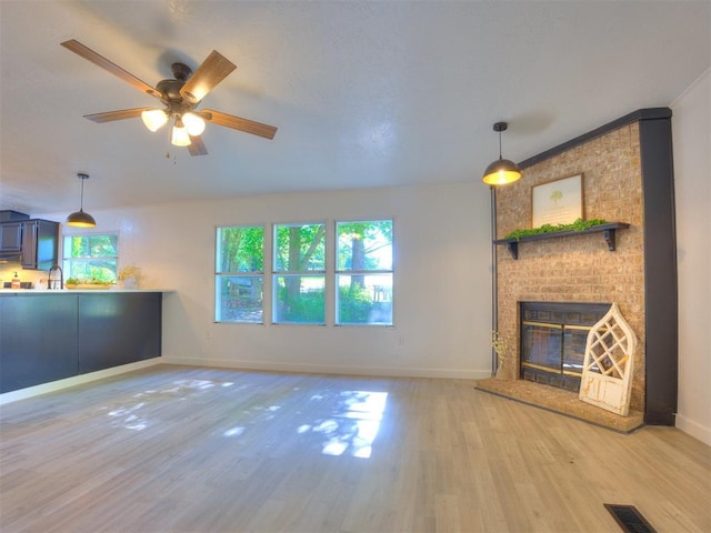 9200 Hollow Rd, Newalla, OK 74857 - unfurnished living room featuring light wood-style floors, a ceiling fan, and a fireplace