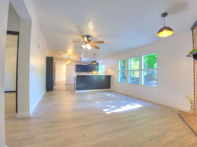 9200 Hollow Rd, Newalla, OK 74857 - unfurnished living room with a ceiling fan, light wood finished floors, and a textured ceiling