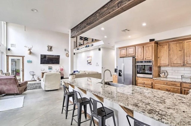 115008 S 4292nd Rd, Porum, OK 74455 - kitchen featuring appliances with stainless steel finishes, open floor plan, light stone countertops, concrete floors, and recessed lighting