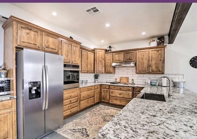 115008 S 4292nd Rd, Porum, OK 74455 - kitchen with stainless steel appliances, under cabinet range hood, decorative backsplash, light stone countertops, and recessed lighting