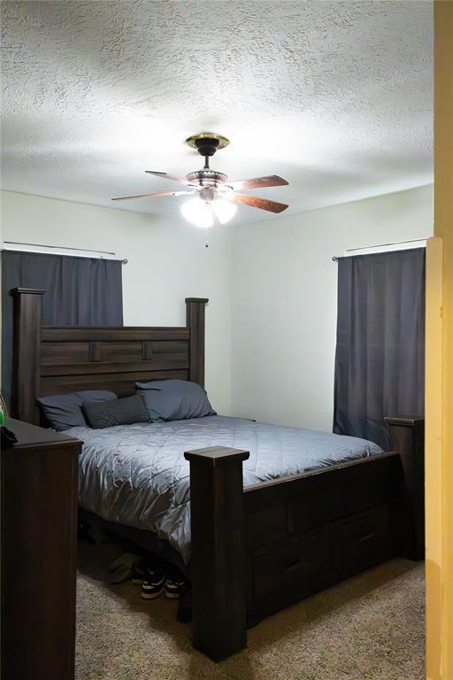 1702 W Boyd St, Norman, OK 73069 - bedroom with a textured ceiling, carpet floors, and ceiling fan