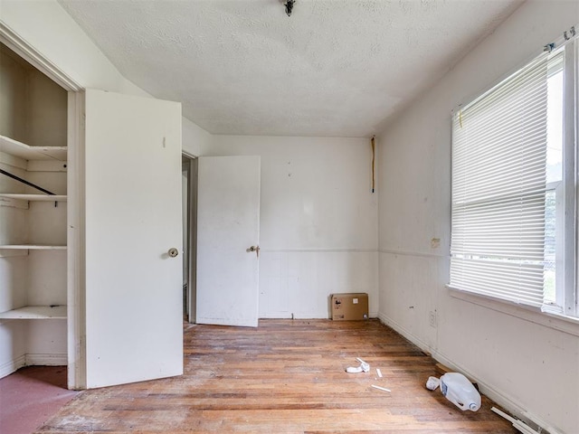 9424 NE 28th St, Oklahoma City, OK 73141 - unfurnished bedroom featuring wood finished floors and a textured ceiling