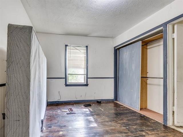 9424 NE 28th St, Oklahoma City, OK 73141 - unfurnished bedroom with wood-type flooring, a textured ceiling, and a closet