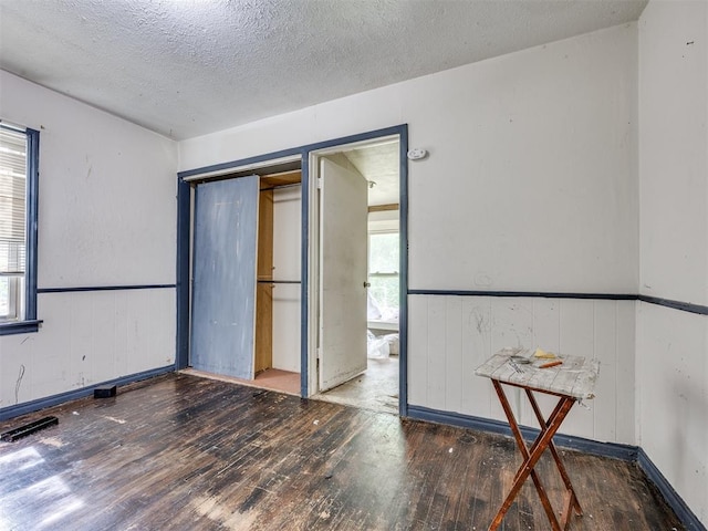 9424 NE 28th St, Oklahoma City, OK 73141 - spare room with hardwood / wood-style flooring, wainscoting, and a textured ceiling