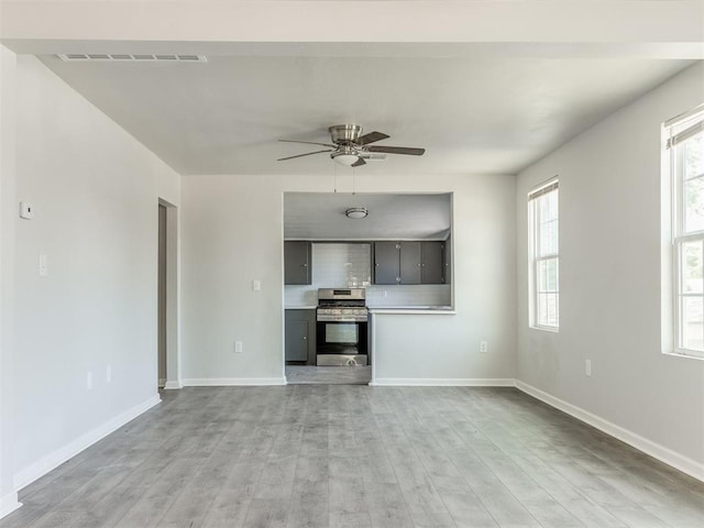 321 W Farrall Ave, Shawnee, OK 74801 - unfurnished living room with light wood-style floors and a ceiling fan