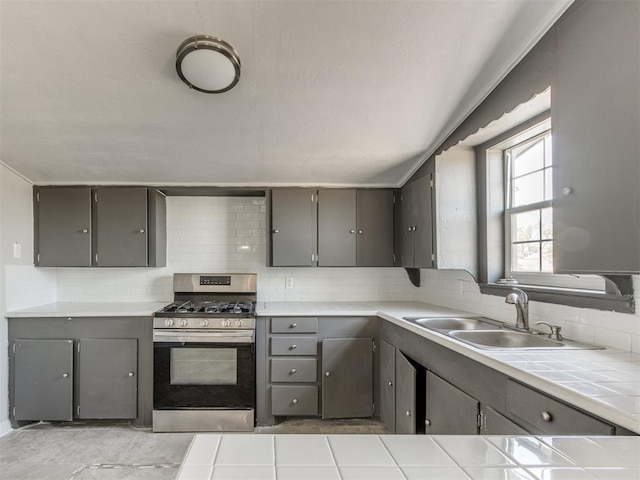 321 W Farrall Ave, Shawnee, OK 74801 - kitchen with stainless steel gas range, gray cabinetry, tile countertops, and backsplash