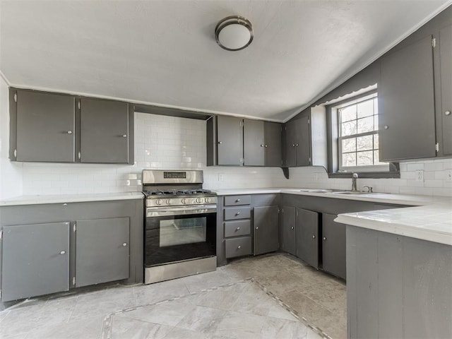 321 W Farrall Ave, Shawnee, OK 74801 - kitchen with stainless steel gas range oven, gray cabinets, tasteful backsplash, light countertops, and lofted ceiling
