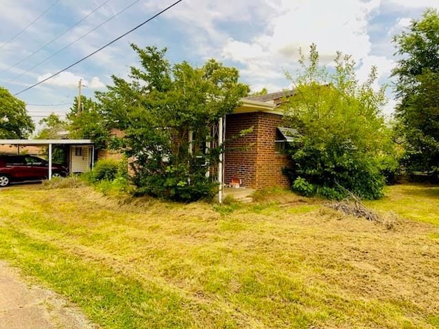 200 E Green St, Meeker, OK 74855 - view of home's exterior featuring a lawn and brick siding