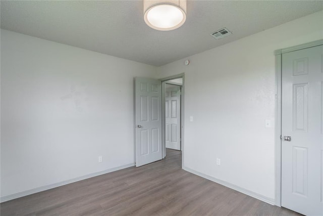 4720 S Youngs Blvd, Oklahoma City, OK 73119 - unfurnished bedroom with wood finished floors and a textured ceiling