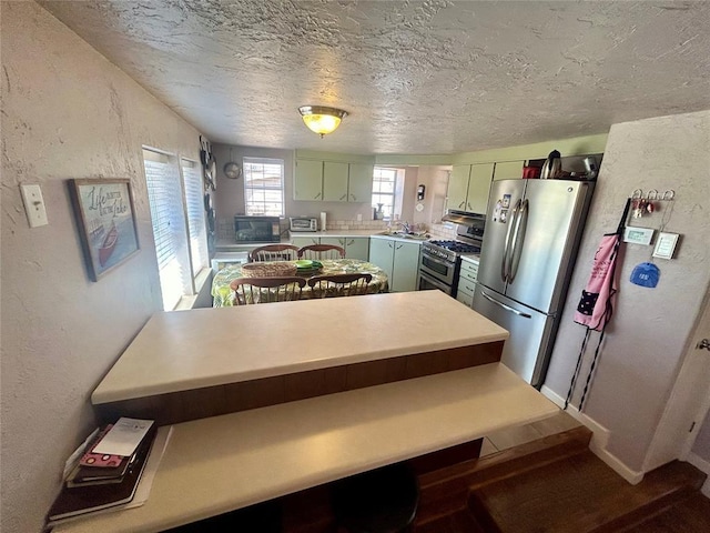 273 N Elm St Unit 1, Eufaula, OK 74432 - kitchen featuring stainless steel appliances, green cabinetry, light countertops, a textured ceiling, and a textured wall