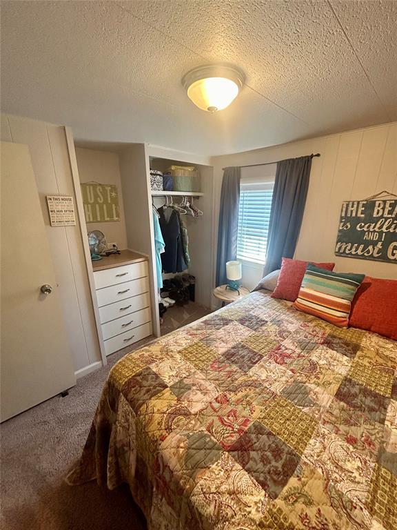 273 N Elm St Unit 1, Eufaula, OK 74432 - bedroom featuring carpet flooring, a textured ceiling, and a closet