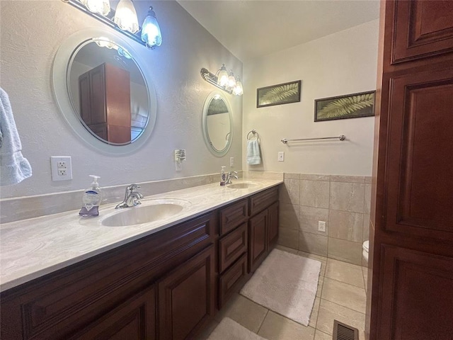 273 N Elm St Unit 1, Eufaula, OK 74432 - full bath with tile patterned flooring, double vanity, tile walls, and a wainscoted wall