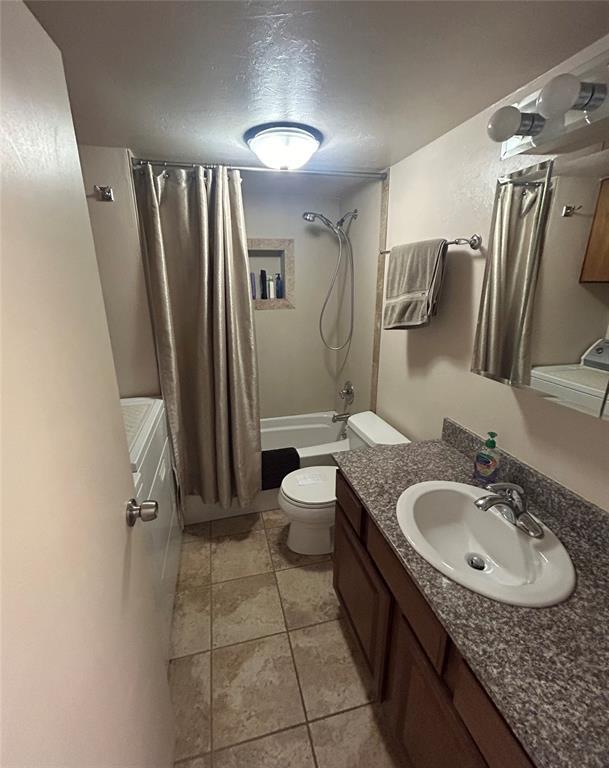 273 N Elm St Unit 1, Eufaula, OK 74432 - bathroom featuring shower / bathtub combination with curtain, vanity, tile patterned floors, and a textured ceiling