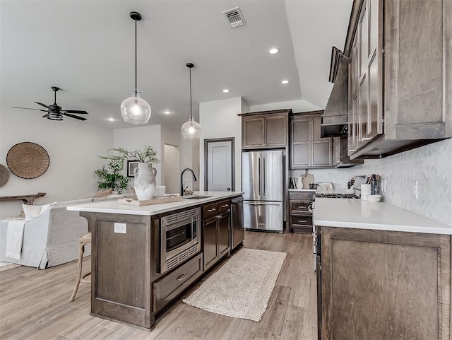 2436 NW 179th St, Edmond, OK 73012 - kitchen featuring appliances with stainless steel finishes, a breakfast bar area, light wood-style floors, light countertops, and recessed lighting