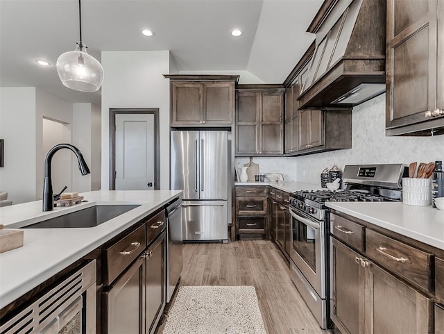 2436 NW 179th St, Edmond, OK 73012 - kitchen with stainless steel appliances, custom exhaust hood, dark brown cabinetry, light countertops, and recessed lighting