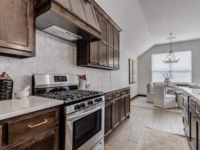 2436 NW 179th St, Edmond, OK 73012 - kitchen with stainless steel gas range, custom range hood, dark brown cabinetry, lofted ceiling, and tasteful backsplash