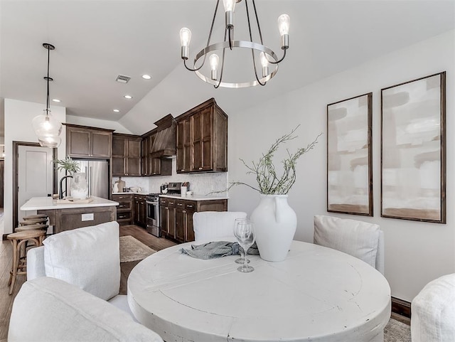 2436 NW 179th St, Edmond, OK 73012 - dining space featuring wood finished floors, a chandelier, vaulted ceiling, and recessed lighting