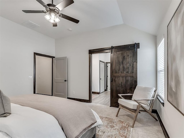 2436 NW 179th St, Edmond, OK 73012 - bedroom with light colored carpet, vaulted ceiling, a barn door, and a ceiling fan
