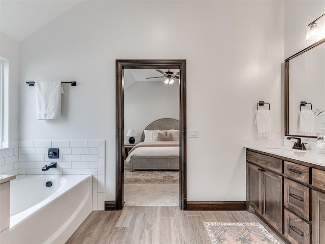 2436 NW 179th St, Edmond, OK 73012 - ensuite bathroom featuring a ceiling fan, wood finished floors, a garden tub, vanity, and lofted ceiling