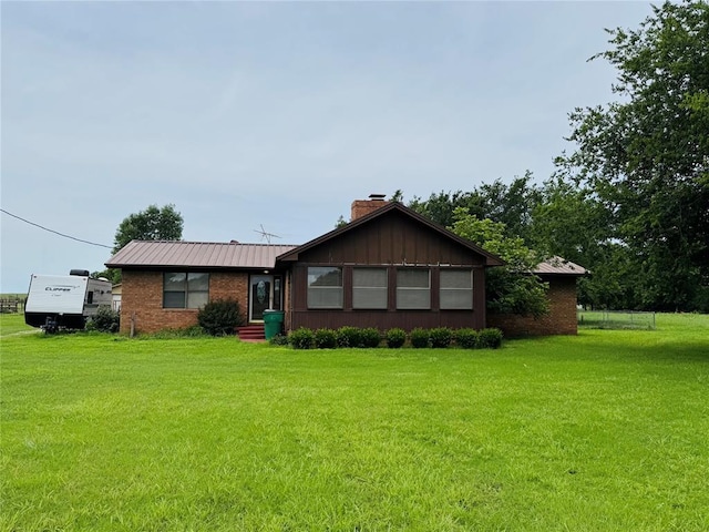 311 Parker St, Waurika, OK 73573 - ranch-style home featuring a chimney, a front yard, and a metal roof