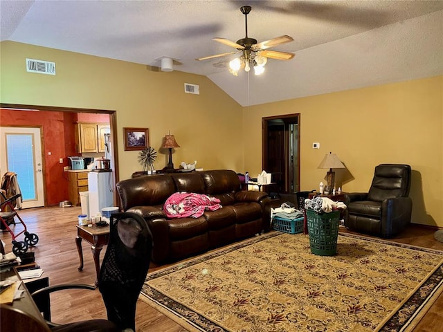 311 Parker St, Waurika, OK 73573 - living room with lofted ceiling, a ceiling fan, light wood-style flooring, and a textured ceiling