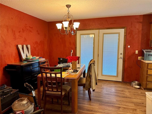 311 Parker St, Waurika, OK 73573 - dining area with a chandelier, wood finished floors, and a textured ceiling