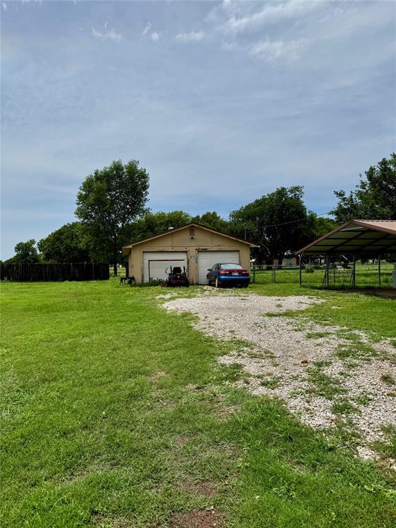 311 Parker St, Waurika, OK 73573 - view of yard featuring a detached garage and an outdoor structure