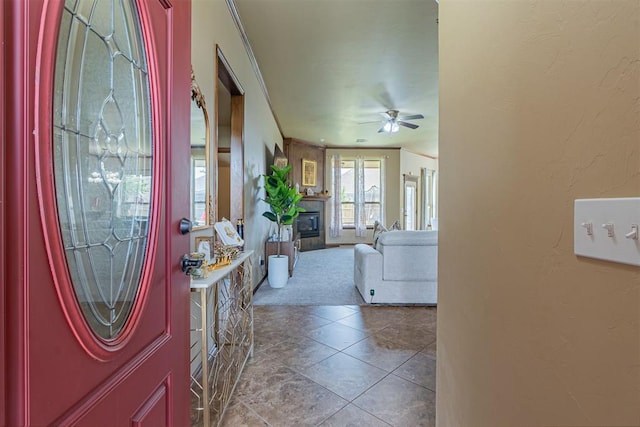 716 SW 157th St, Oklahoma City, OK 73170 - carpeted entryway featuring ceiling fan, a glass covered fireplace, and tile patterned floors