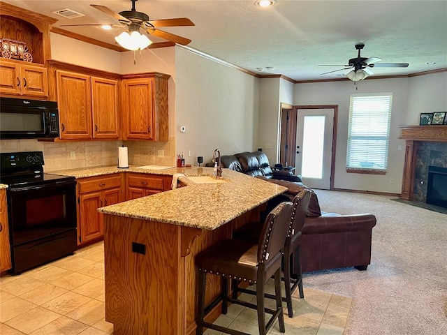 8905 Ava Ave, Oklahoma City, OK 73149 - kitchen with black appliances, open floor plan, a ceiling fan, a peninsula, and a kitchen bar