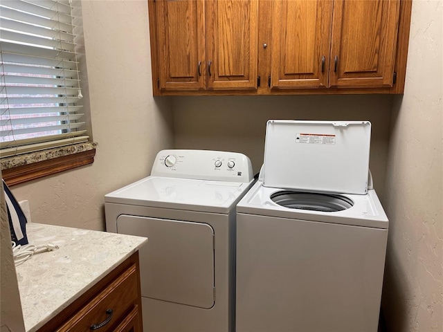 8905 Ava Ave, Oklahoma City, OK 73149 - laundry area with washing machine and clothes dryer, cabinet space, and a textured wall