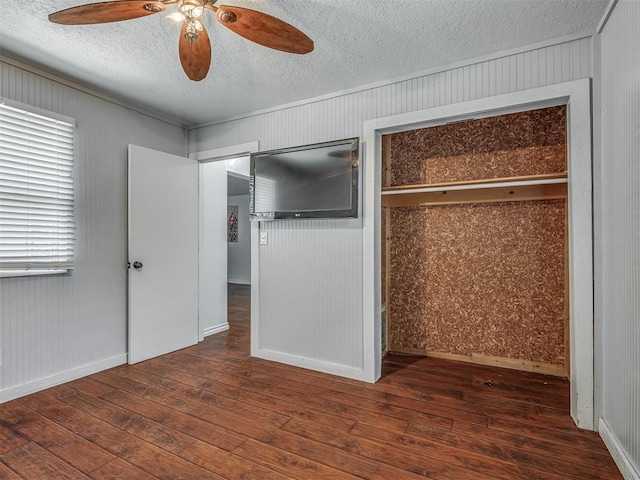 1209 Dakota St, Norman, OK 73069 - unfurnished bedroom with wood-type flooring, a textured ceiling, wooden walls, and ceiling fan