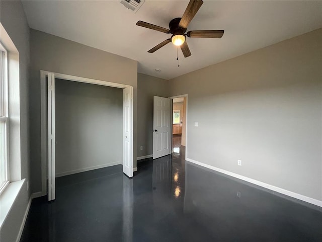17008 County St Unit 2750, Minco, OK 73059 - unfurnished bedroom with concrete flooring, a closet, a ceiling fan, and multiple windows