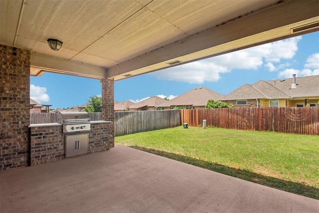 8401 NW 140th St, Oklahoma City, OK 73142 - fenced backyard featuring a patio and an outdoor kitchen