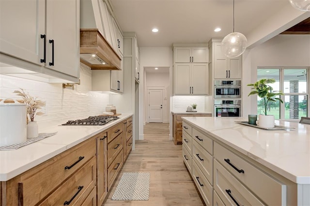 1801 Cedar Valley Mnr, Guthrie, OK 73044 - kitchen with stainless steel appliances, premium range hood, backsplash, light stone countertops, and light wood-style floors