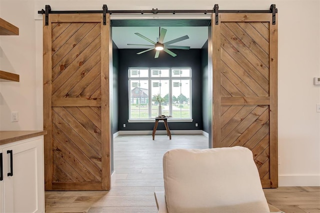 1801 Cedar Valley Mnr, Guthrie, OK 73044 - living area featuring a barn door, ceiling fan, and light wood-type flooring