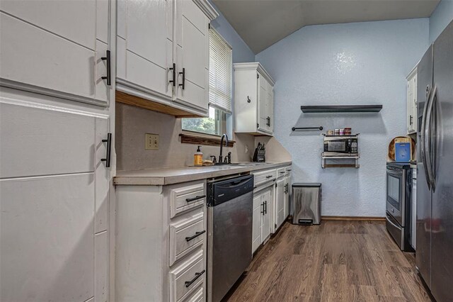912 S Boynton Ave, El Reno, OK 73036 - kitchen with appliances with stainless steel finishes, light countertops, vaulted ceiling, dark wood-style flooring, and white cabinetry
