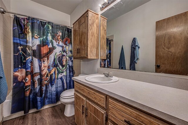 912 S Boynton Ave, El Reno, OK 73036 - bathroom with wood finished floors, vanity, and shower / bath combo with shower curtain