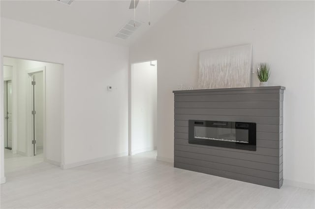316 SE 45th St, Oklahoma City, OK 73129 - unfurnished living room featuring a glass covered fireplace, lofted ceiling, and ceiling fan
