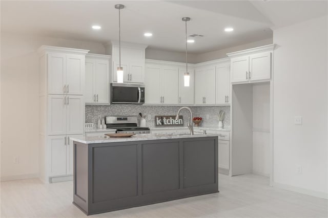 316 SE 45th St, Oklahoma City, OK 73129 - kitchen with stainless steel appliances, white cabinetry, backsplash, a kitchen island with sink, and recessed lighting