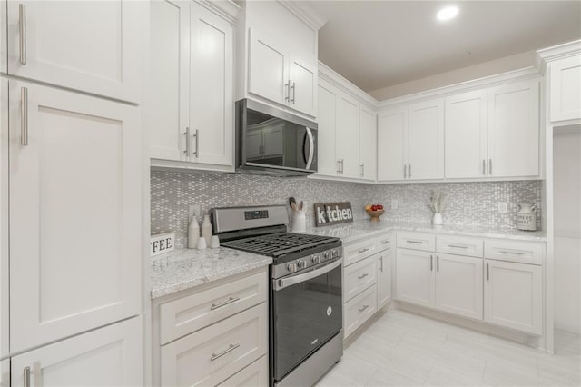 316 SE 45th St, Oklahoma City, OK 73129 - kitchen with appliances with stainless steel finishes, light stone countertops, tasteful backsplash, and white cabinets