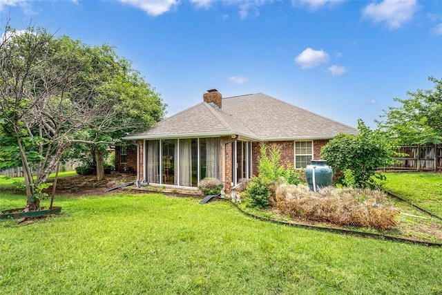 817 NW 76th St, Lawton, OK 73505 - back of house with a chimney, brick siding, a sunroom, and roof with shingles