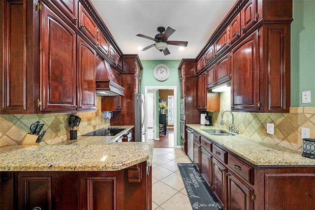 817 NW 76th St, Lawton, OK 73505 - kitchen featuring reddish brown cabinets, custom exhaust hood, black electric cooktop, ceiling fan, and light stone countertops