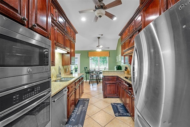 817 NW 76th St, Lawton, OK 73505 - kitchen featuring appliances with stainless steel finishes, a ceiling fan, light stone countertops, light tile patterned floors, and recessed lighting