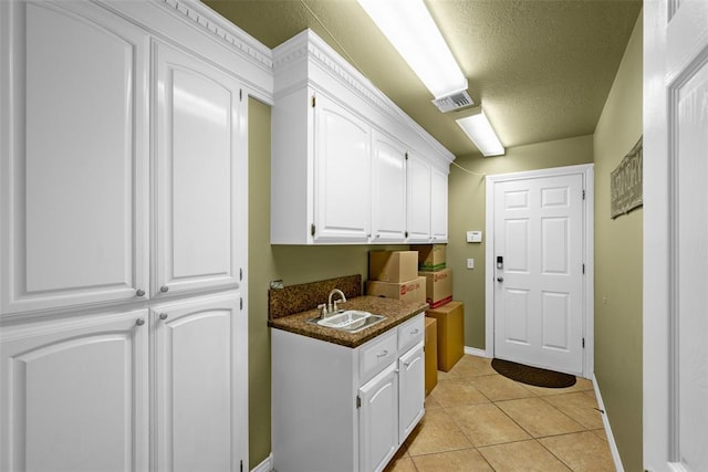 817 NW 76th St, Lawton, OK 73505 - washroom featuring a textured ceiling and light tile patterned floors