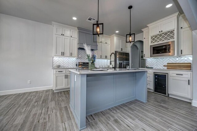 1890 E Industrial Rd, Guthrie, OK 73044 - kitchen with beverage cooler, stainless steel microwave, black fridge, decorative backsplash, and light countertops