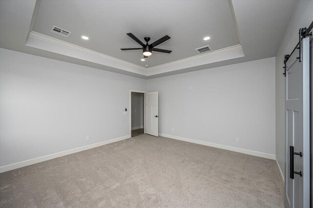 1890 E Industrial Rd, Guthrie, OK 73044 - unfurnished bedroom with a barn door, a raised ceiling, ornamental molding, carpet floors, and recessed lighting