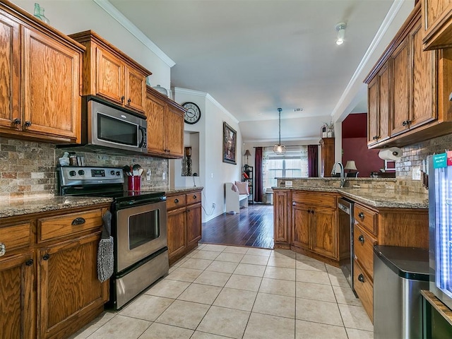 1205 NW 190th Pl, Edmond, OK 73012 - kitchen with stainless steel appliances, brown cabinetry, backsplash, light tile patterned flooring, and crown molding