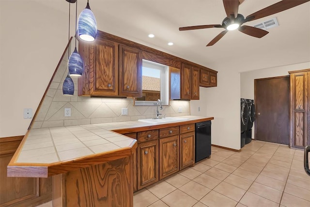 3217 Quail Cir, Altus, OK 73521 - kitchen featuring tile counters, independent washer and dryer, dishwasher, a ceiling fan, and tasteful backsplash
