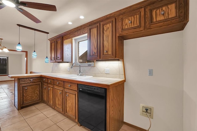 3217 Quail Cir, Altus, OK 73521 - kitchen with black dishwasher, brown cabinetry, a peninsula, tasteful backsplash, and tile counters
